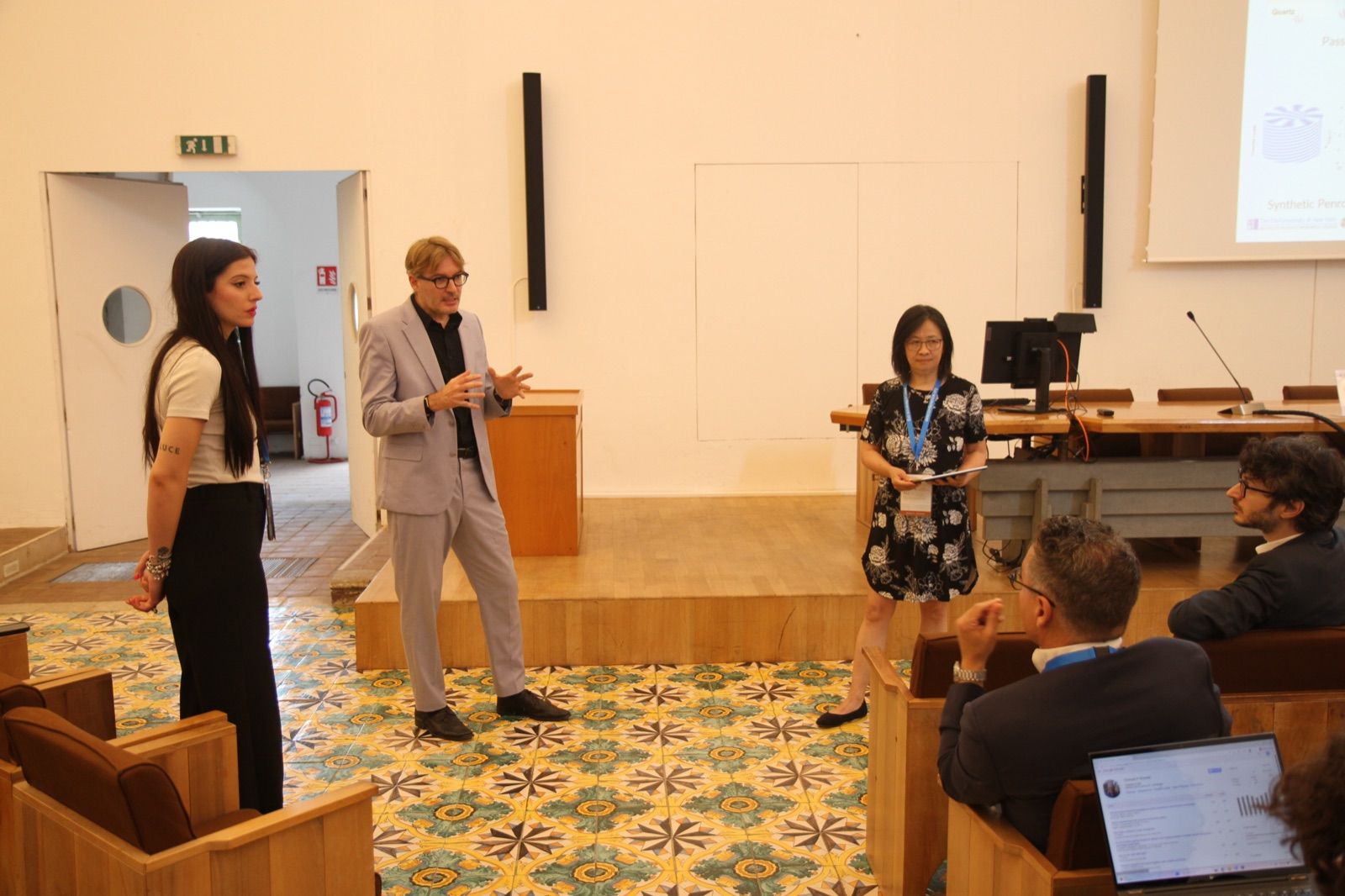 A talk in a session room at AES 2026: the presentation on the screen, participants seated at the tables